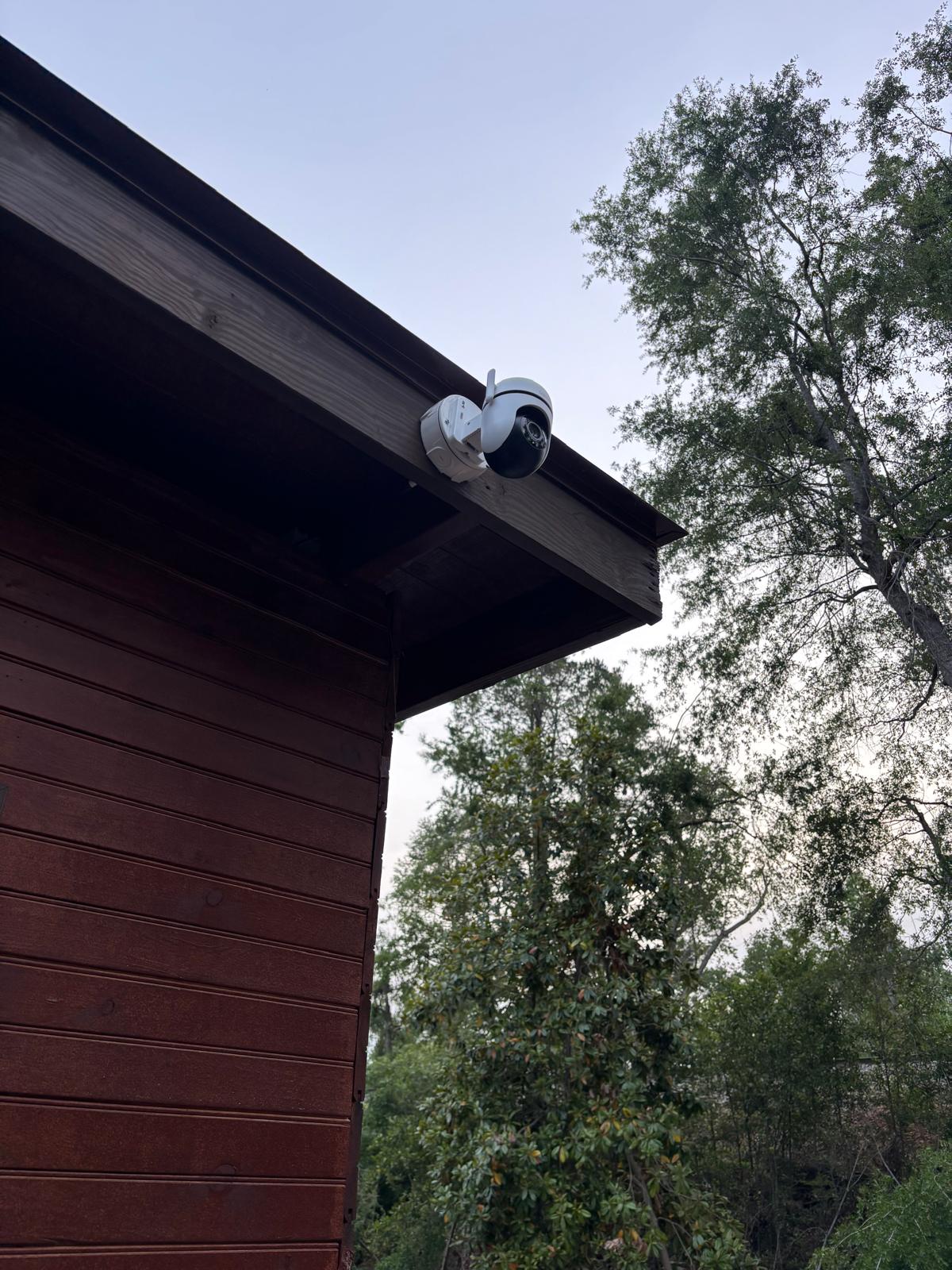 Outdoor security camera installed under a residential roof edge