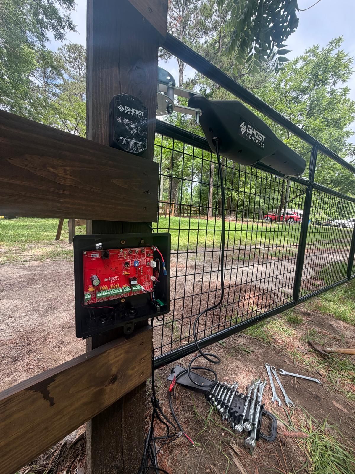 Smart automatic gate opener control system installed on a black metal gate by CAMINTEL