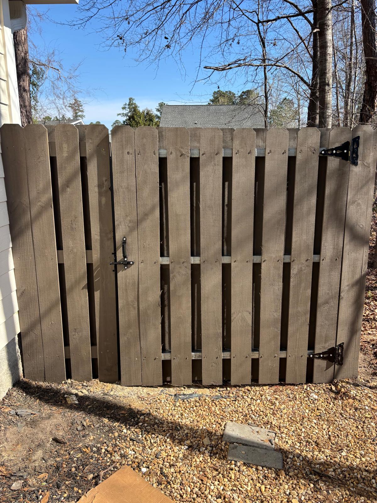 Completed stained wood privacy gate with black hardware
