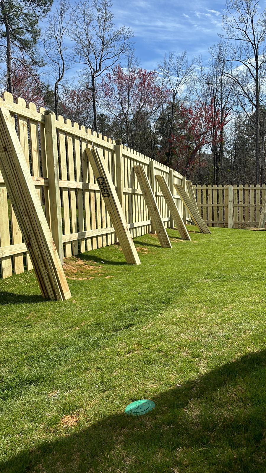 Wood fence installation supported with temporary bracing during construction