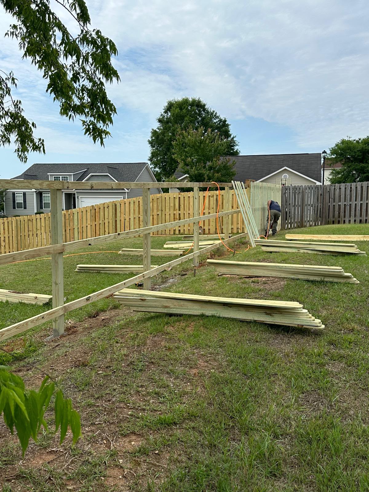 CAMINTEL wood privacy fence installation in progress with posts and materials prepared