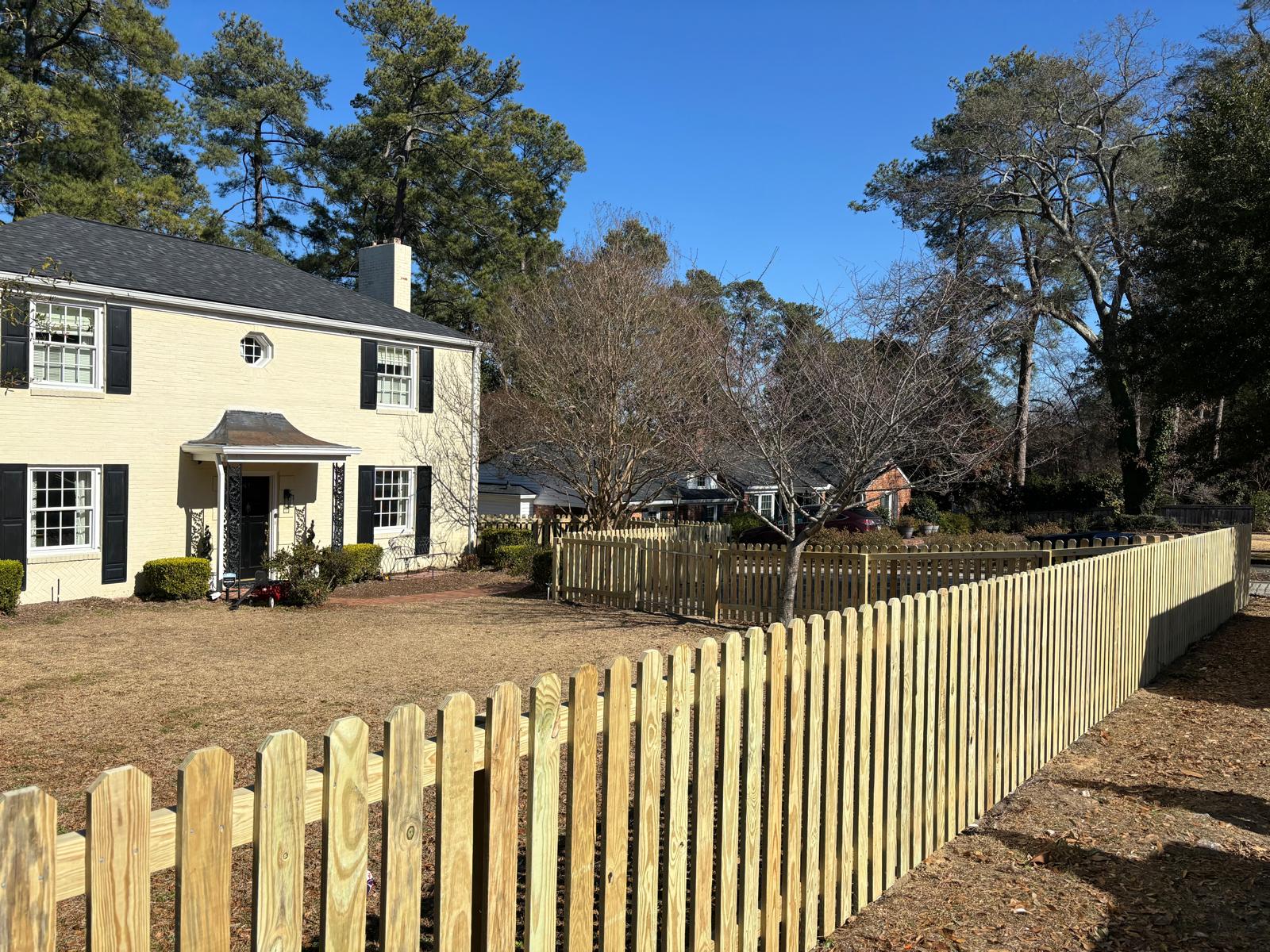 Completed wood picket fence surrounding a residential property